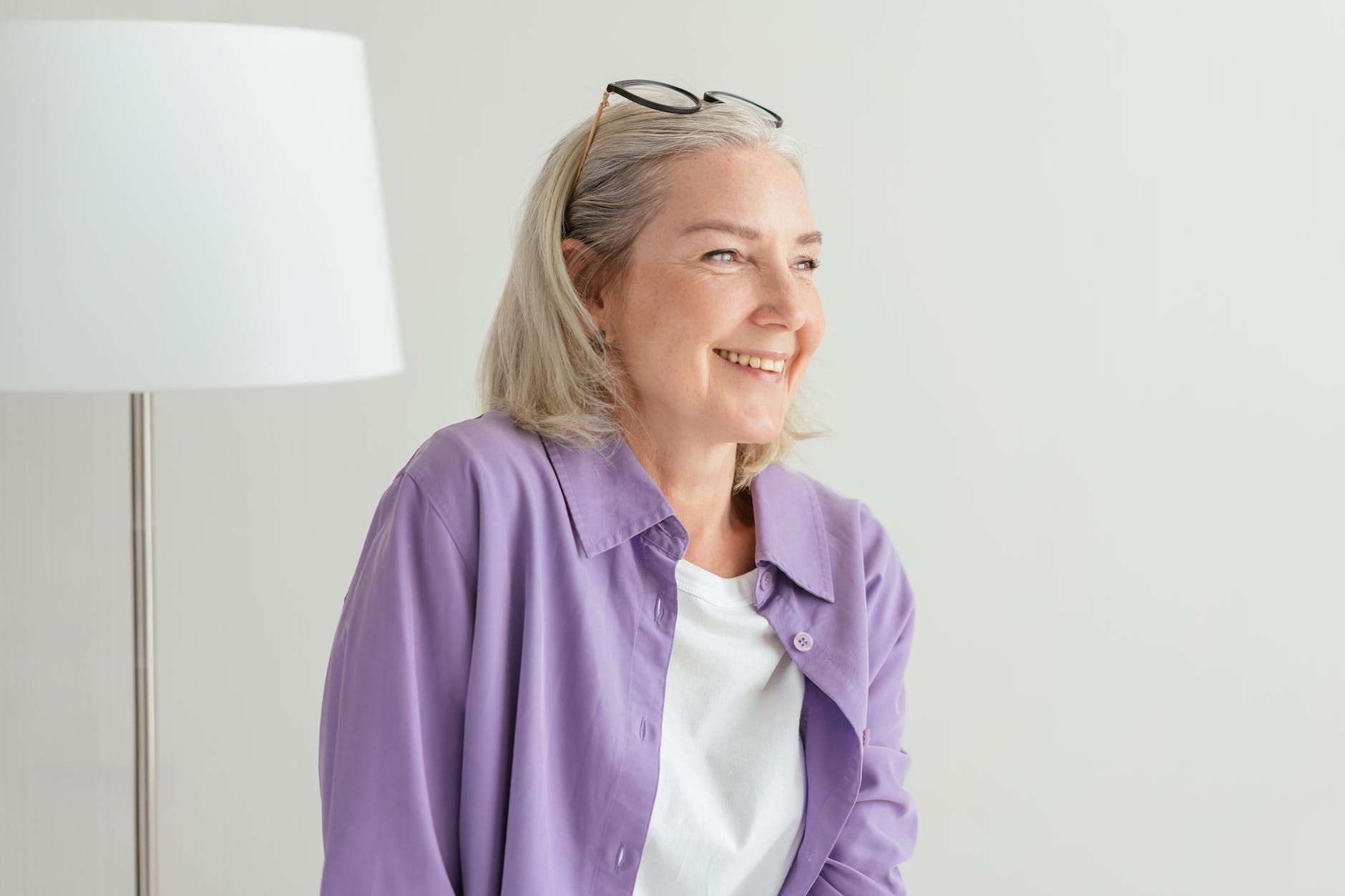 an elderly woman in Canada in purple long sleeves smiling about OAS payment dates